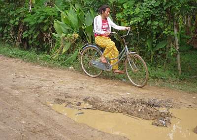 Girl on a bicycle in the mud